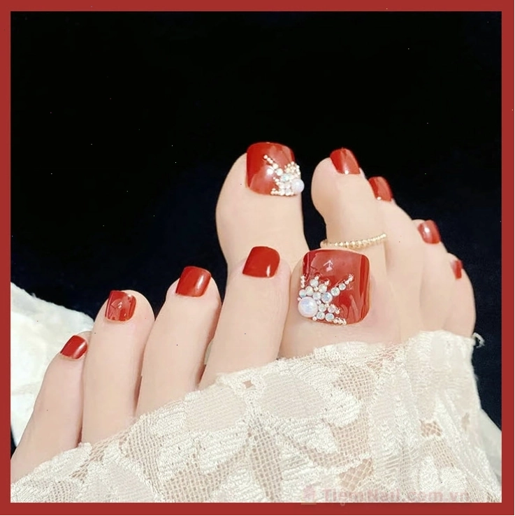 Mẫu móng chân đẹp màu đỏ đính đá lung linh, tạo vẻ sang trọng và quý phái